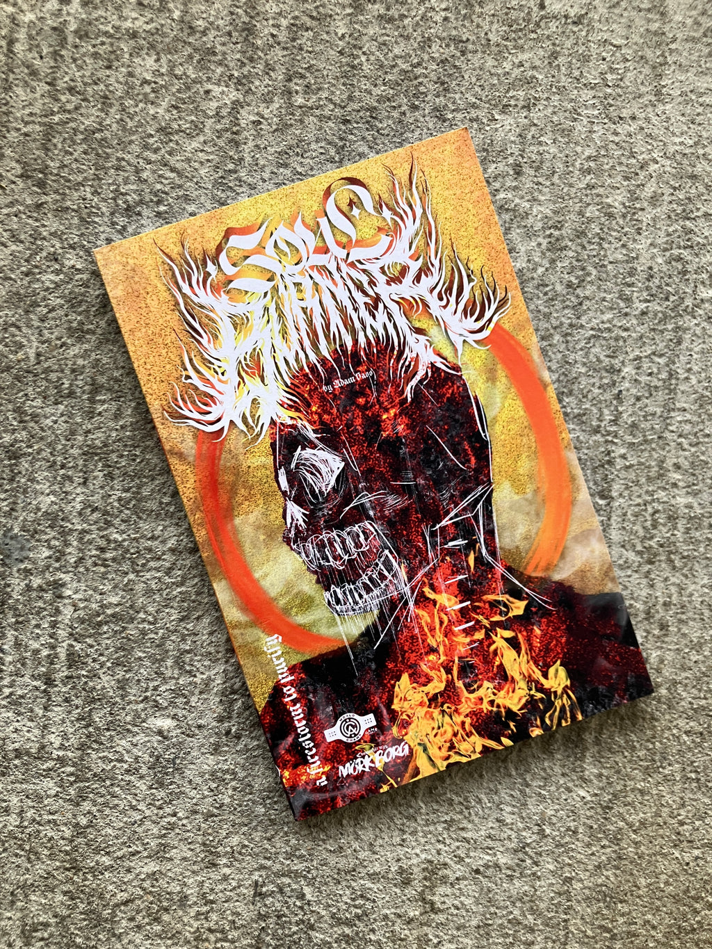 Soul Burner by World Champ Game Co book cover. The title is written in a heavy metal style and there is a silhouette from the shoulders up of a person. The silhouette looks like it is on fire and burning